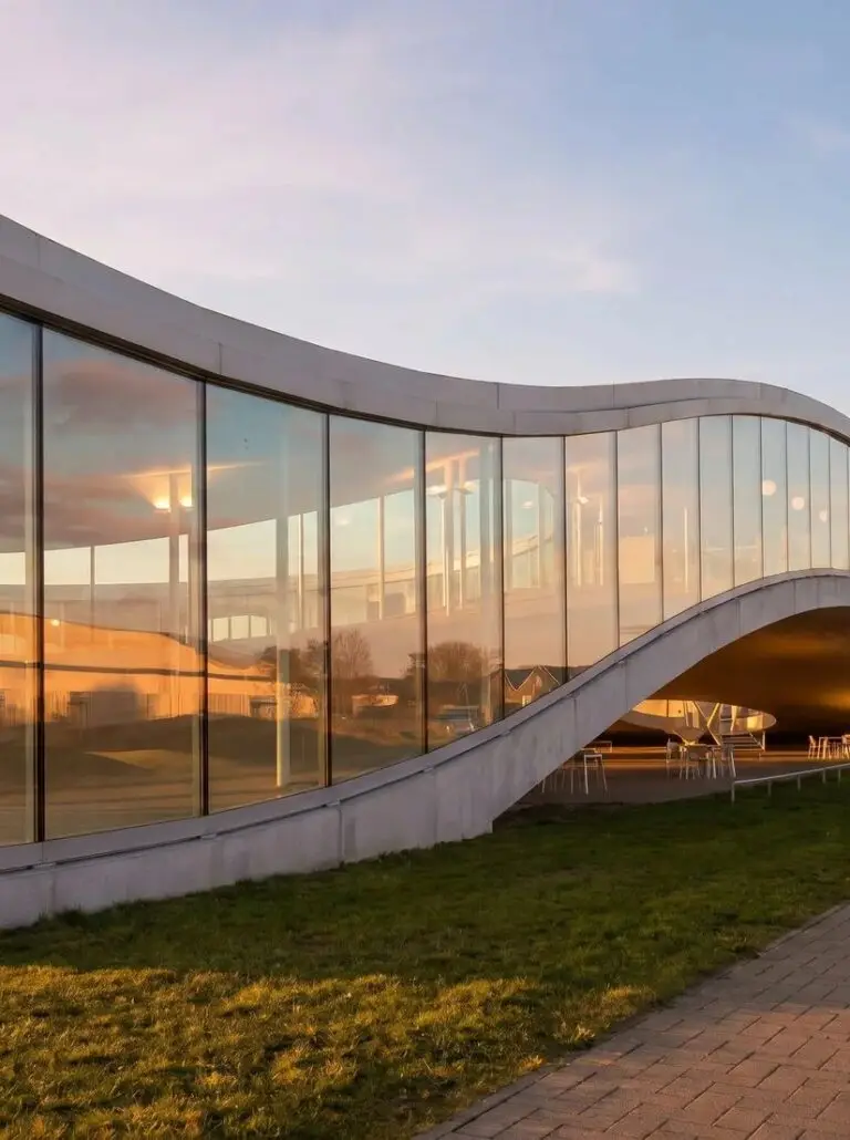 Bâtiment vitré courbé au coucher de soleil, photographe architecture Normandie