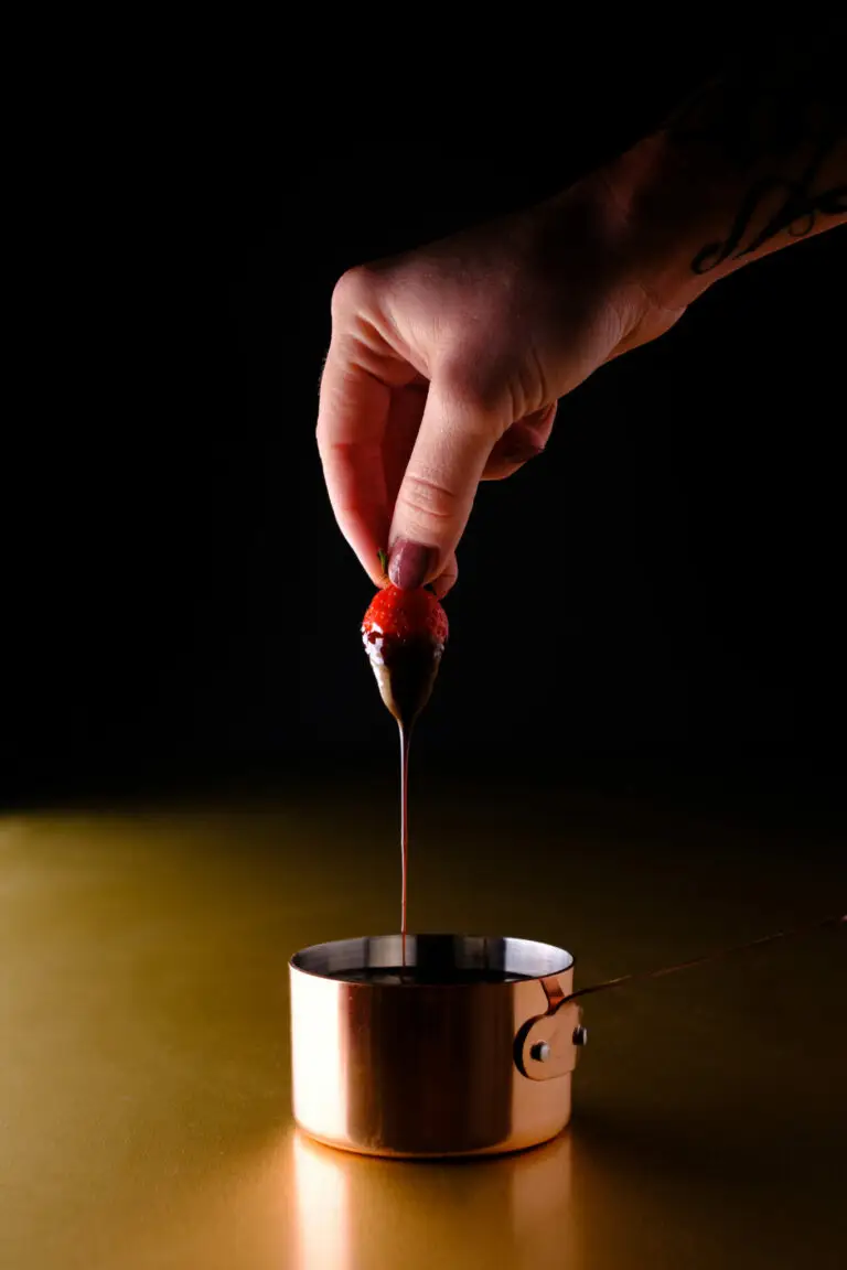 Fraise trempée chocolat fondu casserole cuivre fond noir, photographe culinaire Caen