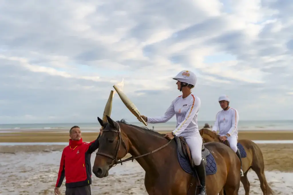 Porteuse de la flamme olympique 2024 à cheval sur la plage d'Omaha Beach en Normandie — Photo 911