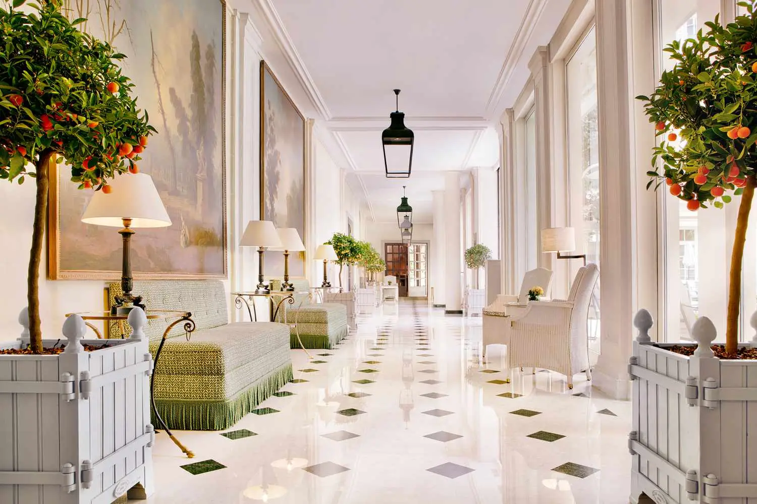 Hall d'entrée d'un hôtel haut de gamme en Normandie avec couloir élégant et orangers décoratifs